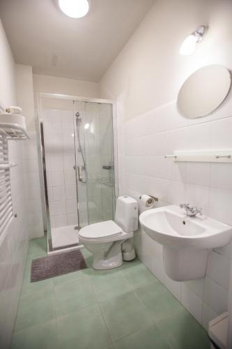 a bathroom with a toilet and a shower and a sink at Pokoje Przy Plaży in Mielno