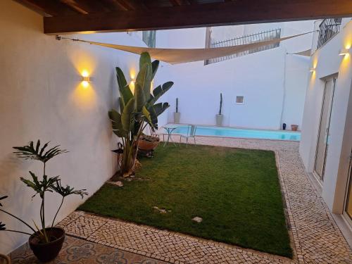 a courtyard with a green lawn and a swimming pool at Santa Cruz - B&B in Lagos