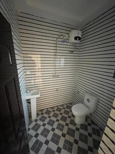a bathroom with a toilet and a sink at CasaCasa Apartments in Enugu