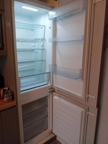 an empty refrigerator with its door open in a kitchen at Compact one bed apartment near University of Limerick in Gilloge Bridge