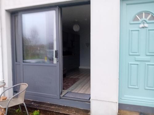 a door to a patio with a table and a chair at Compact one bed apartment near University of Limerick in Gilloge Bridge