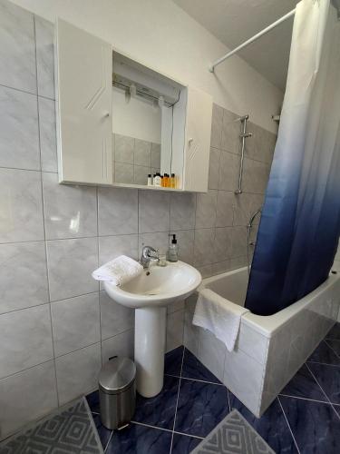 a bathroom with a sink and a bath tub at Kia Ora in Bihać