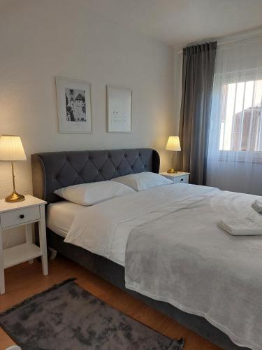 a bedroom with a large bed with two tables and two lamps at Kia Ora in Bihać