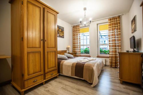 1 dormitorio con 1 cama y un gran armario de madera en Pokoje Przy Plaży, en Mielno
