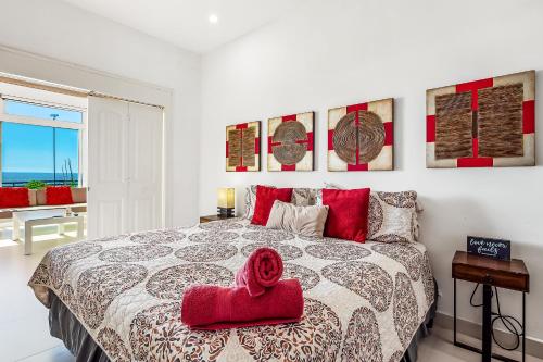 een slaapkamer met een bed met een rode handdoek erop bij Villa San Valentin 48 - Playa Arcangel in Rosarito