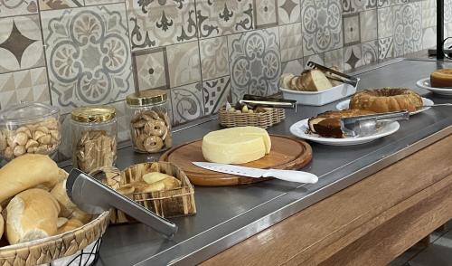 a counter with bread and cheeses and other foods at Hotel Águas Lindas in Itamonte