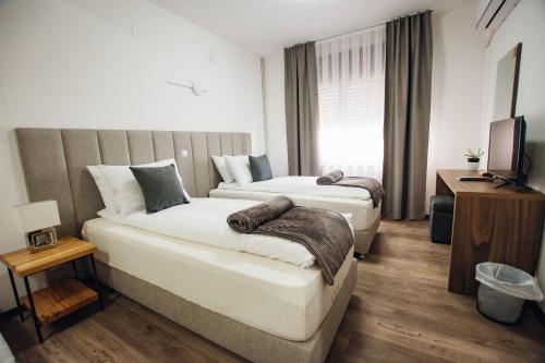 a hotel room with two beds and a television at Urban Studio Apartments in Strumica