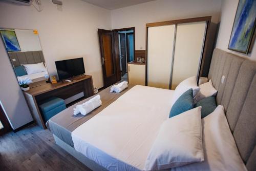 a hotel room with a large bed and a television at Urban Studio Apartments in Strumica