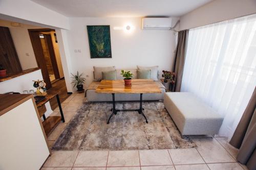 una pequeña sala de estar con mesa y sofá en Urban Studio Apartments en Strumica