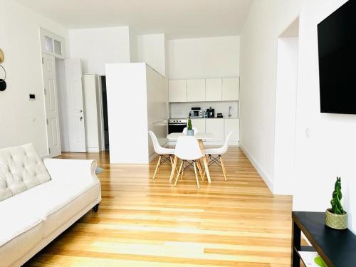 een woonkamer met een witte bank en een tafel bij 8 VILLAS Hotel in Santo Tirso