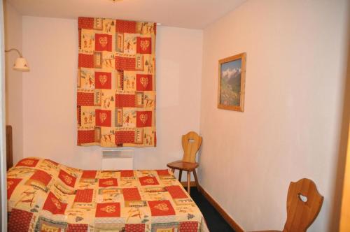 une chambre avec un lit et une courtepointe au mur dans l'établissement Primevere Chalets De La Vallee D'or - 3 pièces 6 personnes 3 exposé Ouest MAE-9954, à Valloire