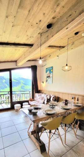 - un salon avec une grande table et des chaises en bois dans l'établissement Résidence Les Chardons - Appartement calme avec des vues superbes, à proximité des pistes de ski et des randonnées. MAE-2854, à Notre-Dame-de-Bellecombe