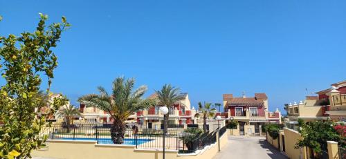a row of houses and a street with palm trees at Apartment Altos De La Bahia X in Torrevieja