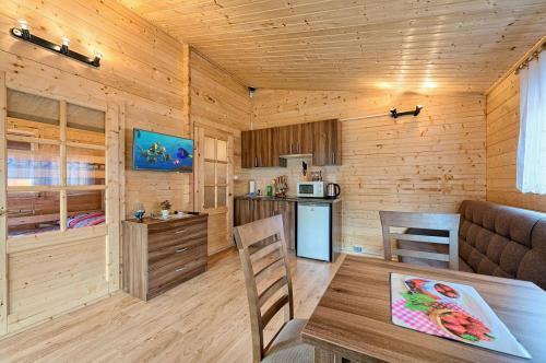 a kitchen and a living room with a table in a cabin at RODOS Rowy Domki nad morzem in Rowy