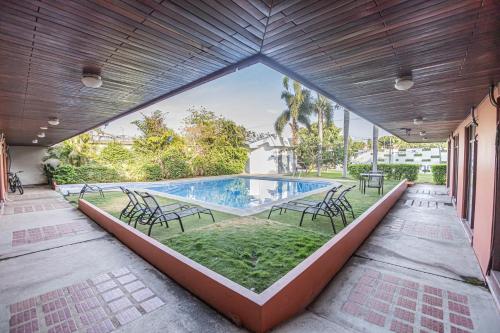 a swimming pool with chairs and a patio at Hotel Caña Brava Inn in Cañas
