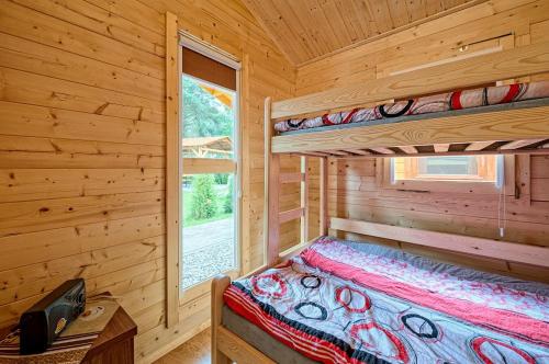 a bedroom with two bunk beds in a log cabin at RODOS Rowy Domki nad morzem in Rowy