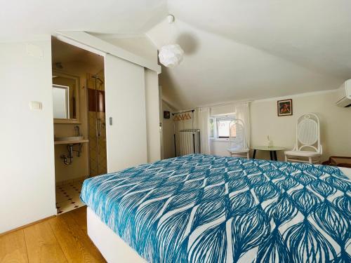 1 dormitorio con 1 cama con colcha azul y blanca en Villa Verde Piran - Newly Opened 2024!, en Piran