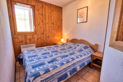 una camera con un letto in una stanza con una finestra di Résidence Les Oursons - 3 Pièces pour 6 Personnes 394 a Notre-Dame-de-Bellecombe