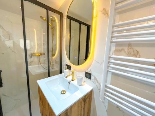 y baño con lavabo blanco y espejo. en La Suite Majorelle, en LʼIsle-sur-la-Sorgue