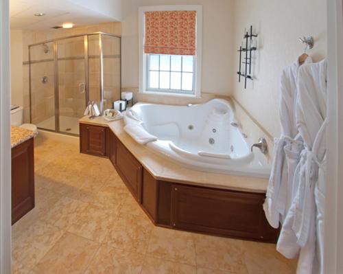 La salle de bains spacieuse est pourvue d'une grande baignoire et d'une douche. dans l'établissement The Essex Resort & Spa, à Burlington