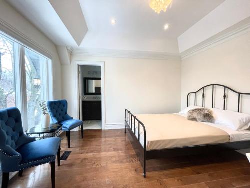 una camera con un letto e due sedie blu di Vihome520-Beautiful house near North York Center a Toronto