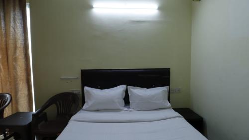 a bed with white sheets and pillows in a room at ROYAL PARK NEAR BELLANDHUR,HSR in Bangalore