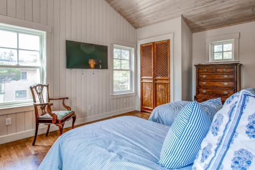 a bedroom with a bed and a chair and a dresser at Modern Gearhart Getaway, Walk to Beach and Downtown! in Gearhart