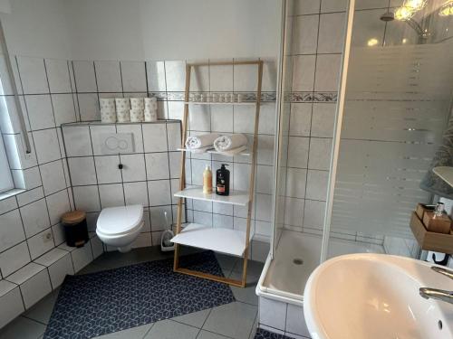 a bathroom with a toilet and a sink and a tub at Stadtnahen Wohnung I Küche I Oelde in Oelde