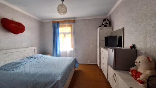 sypialnia z łóżkiem i pluszowym misiem w obiekcie Guest House "SVANETI" w mieście Lentekhi