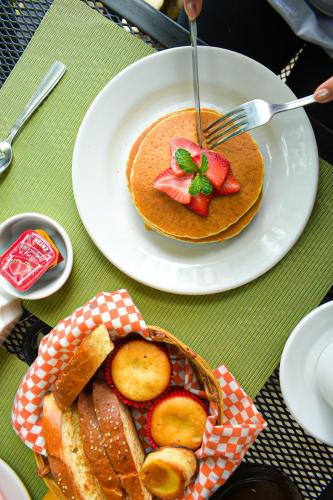 a table with two plates of pancakes and a basket of bread at Hotel Nututun Palenque in Palenque