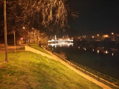 a river at night with a boat in the water at ELISIA STUDIO in Oradea