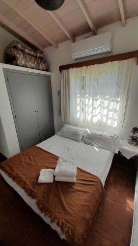 a bedroom with a large bed with towels on it at Casa de Huéspedes Muñiz sobre parque de 1000m2, 1 dormitorio, 20m2 cubiertos, baño con ducha, pileta cilíndrica de 3x076 in Muñiz