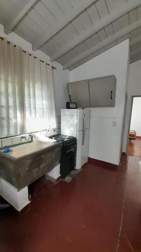 Casa de Huéspedes Muñiz sobre parque de 1000m2, 1 dormitorio, 20m2 cubiertos, baño con ducha, pileta cilíndrica de 3x076 في Muñiz: مطبخ مع حوض استحمام وثلاجة
