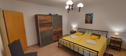 波熱加的住宿－Apartman Orljava，一间卧室配有一张带黄色床单和黄色枕头的床。