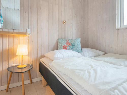 a bedroom with a bed and a table with a lamp at Holiday home Ørsted V in Ørsted