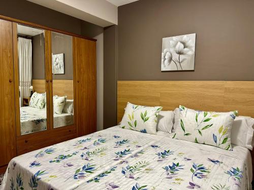 um quarto com uma cama com colcha floral em Apartment in the heart of the Camino de Santiago em Sarria