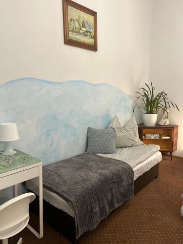 Schlafzimmer mit einem Bett mit blauem Kopfteil in der Unterkunft Magiczny zakątek in Chojnice