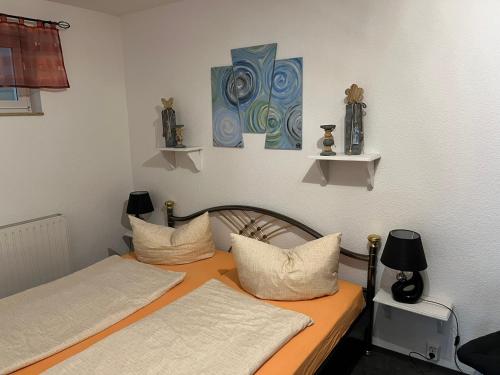 two twin beds in a room with two lamps at Ferienwohnung Hoppelnase mit eigener Sauna in Langenstein
