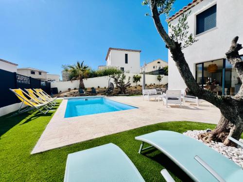 - une piscine dans une cour avec des chaises et un arbre dans l'établissement Villa Mila*Proche plages, à La Garde