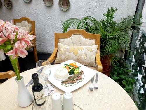 a table with a plate of food and a bottle of wine at Antara Hotel & Suites - Miraflores in Lima