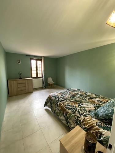 a bedroom with a bed and a table and a window at La maison du Haou in Clermont