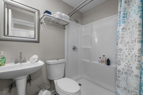 a white bathroom with a toilet and a sink at Downtown Kimmswick Studio Newly Renovated 