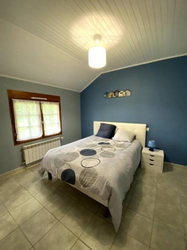 a bedroom with a bed with a blue wall at La maison du Haou in Clermont