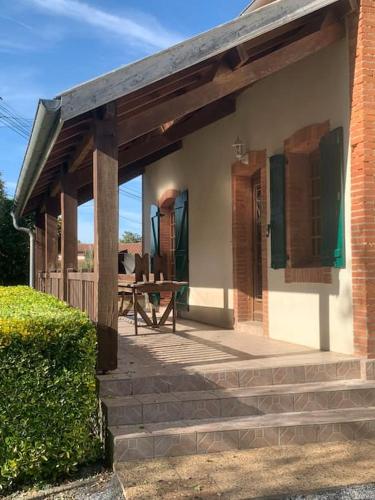 a building with a patio with a table on it at La maison du Haou in Clermont