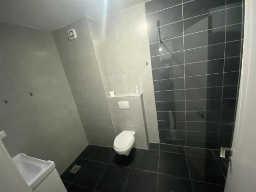 a small bathroom with a toilet and a shower at apartment gjilan in Gjilan