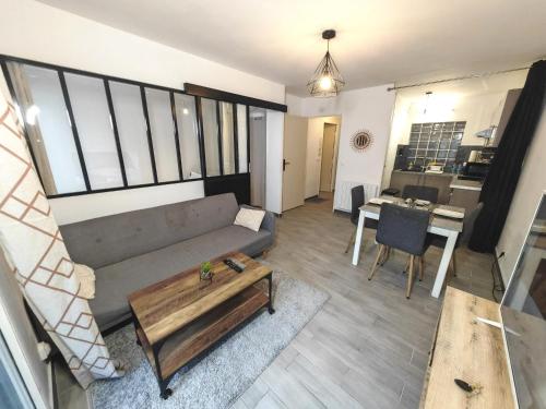 un salon avec un canapé et une table dans l'établissement Appartement avec jardin - Métro 13 - Université Saint Denis, à Saint-Denis