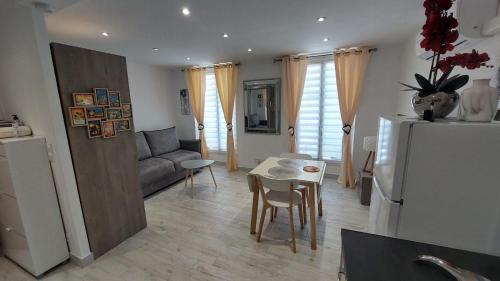 Il dispose d'une cuisine et d'un salon avec un réfrigérateur et une table. dans l'établissement Studio lumineux avec parking proche Monaco, Nice, plage et gare, à Menton