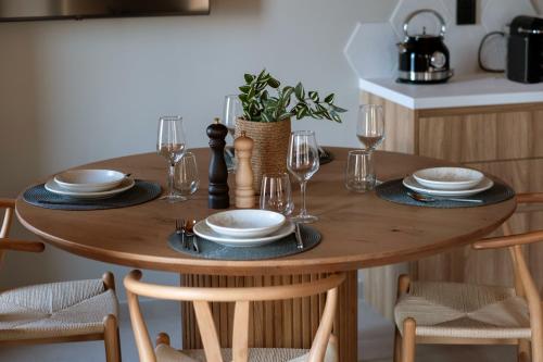a wooden table with plates and wine glasses on it at Orithyia prime living in Kalamata