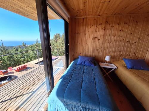 a bedroom with a bed and a large window at Casa Bosquemar Boyeruca in Vichuquén