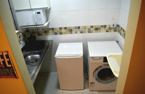 a small kitchen with a washing machine and a sink at 40 LOFT DUPLO · LOFT perto do São Paulo Expo e metrô Jabaquara in Sao Paulo